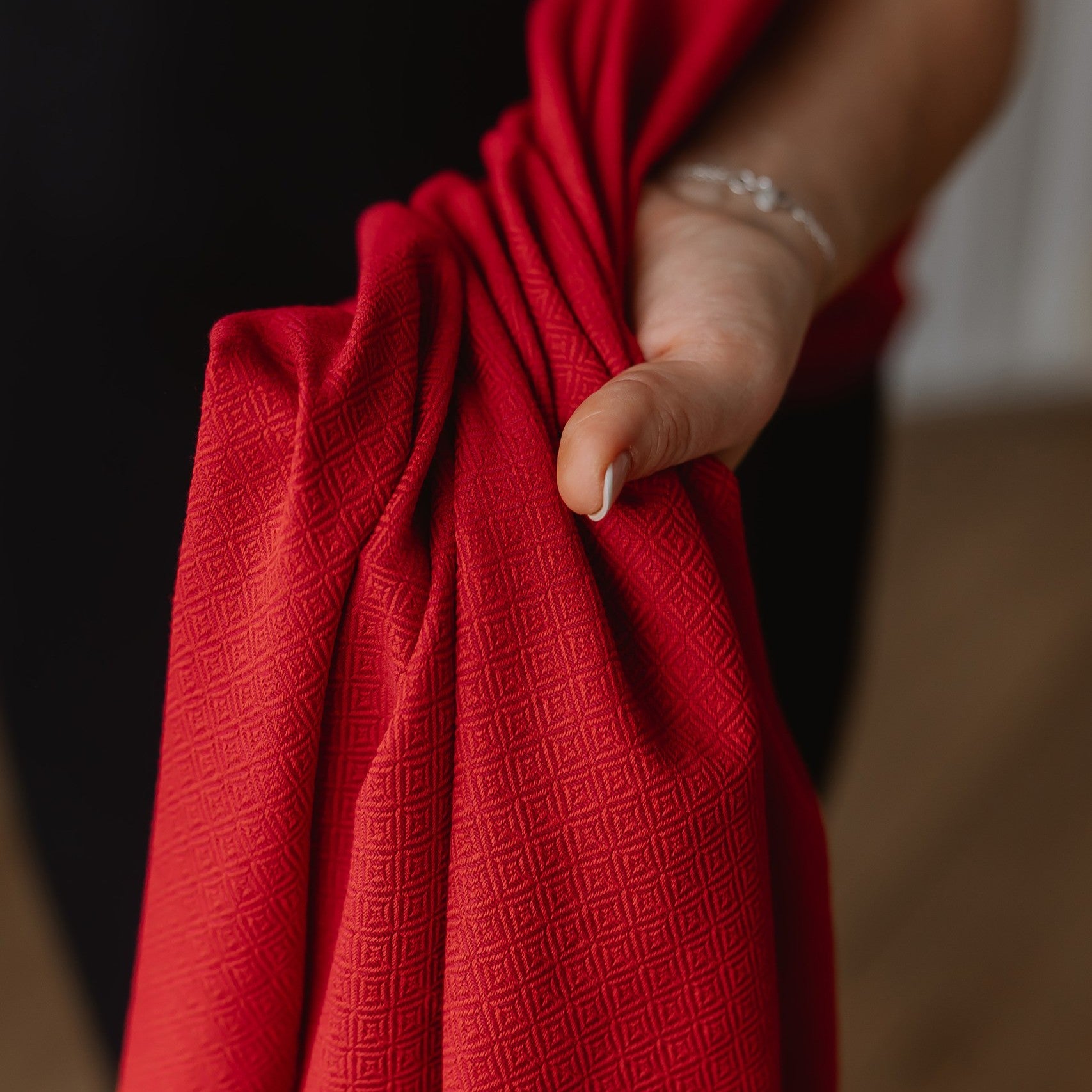 Red baby sling with subtle weave pattern, suitable from birth to toddlerhood, made of OEKO-TEX certified cotton, Tragetuch Leo Rot.